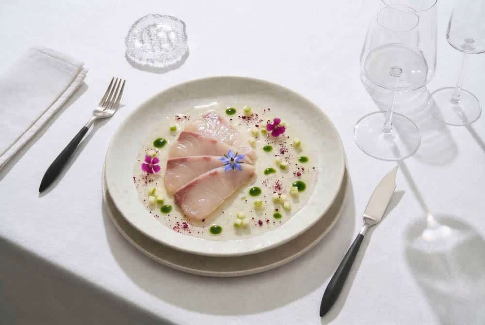 Mesa de alta cocina con vajilla, cubertería y cristalería para restauración – plato gourmet emplatado