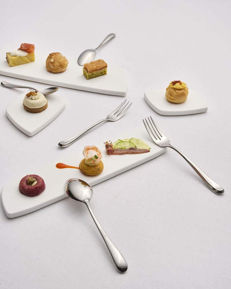 Cubertería mini para aperitivos y petit fours sobre platitos de cerámica – menaje para hostelería