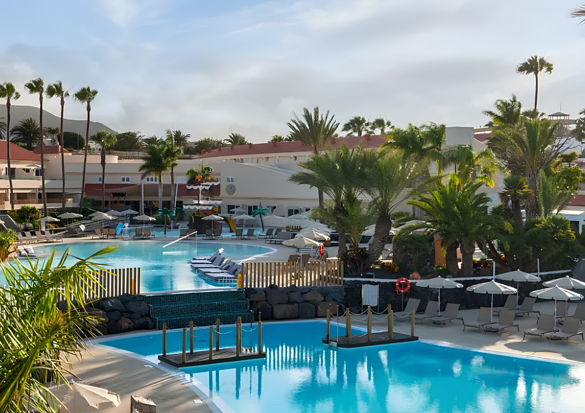 Vista de las piscinas y los jardines con palmeras del hotel HD Lobos Natura Fuerteventura, en Corralejo